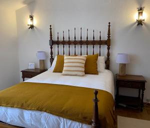 奥比多斯Pátio da Muralha的一间卧室配有一张大床、黄色床单和两盏灯。