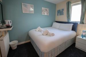 欧文Irvine Riverside Guesthouse by Paymán Club的卧室配有白色床和毛巾