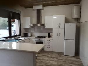 巴尔德甘加Casas Rurales Huerto Del Abuelito的厨房配有白色橱柜和白色冰箱。
