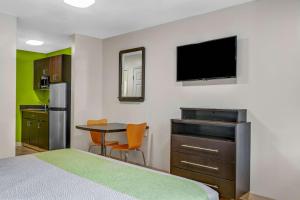 亚特兰大查姆布里6号公寓式酒店的酒店客房配有一张床和一张书桌及一台电视