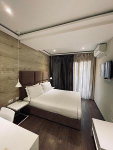 地拉那奥雷斯蒂中心酒店的一间卧室配有一张带白色床单的大床