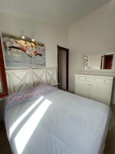 杰若米斯Villetta Azzurra Kal'è Moru的卧室配有一张床,墙上挂有绘画作品