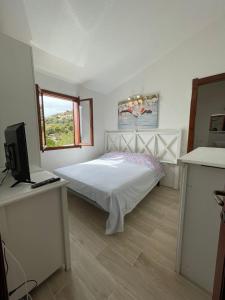杰若米斯Villetta Azzurra Kal'è Moru的卧室配有白色的床和窗户。