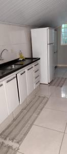 奥林匹亚Casa em Olimpia 2的厨房配有白色橱柜和白色冰箱。