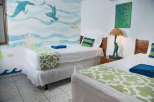 埃尔蒙特Olas Permanentes El Zonte的一间卧室配有两张床,并画有海豚