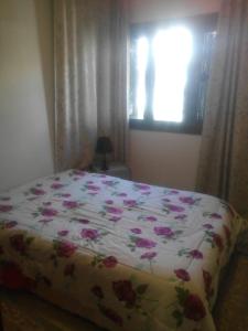 马赫迪耶House with Wala Garden的一间卧室,床上有粉红色的鲜花