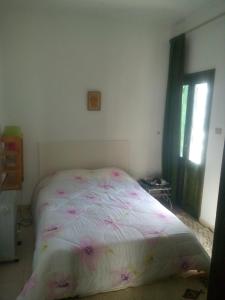 马赫迪耶House with Wala Garden的一间卧室,床上有粉红色的鲜花