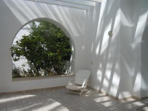 马赫迪耶House with Wala Garden的门廊上的白色椅子,窗户