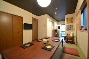 京都Guesthouse Nobi的一间带桌子和电视的用餐室