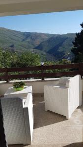 萨布盖鲁Casa na Serra 2, Sabugueiro的阳台上配有2张白色的桌椅,享有风景。