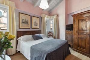 坎诺比奥皮罗尼酒店 的卧室配有一张床铺,位于一间粉红色墙壁的房间