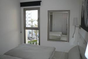 卡拉米洛Modern apartment with stunning sea view的一间卧室配有镜子、一张床和一个窗户