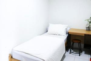 巴东Rumah Kita的卧室配有白色的床和书桌