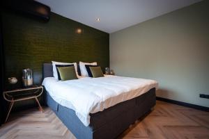皮尔默伦德B&B Bardot的一张大床,位于一个绿色的墙壁内