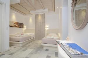 阿吉奥斯普罗科皮奥斯Ostria Hotel的一间卧室配有两张床和镜子