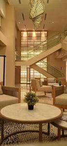 芝卡朗Kawana Golf Residence的大堂设有桌椅和楼梯。