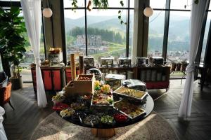 布克维Mountain Residence Apartments & Chalet的窗户客房内的餐桌上供应的自助餐
