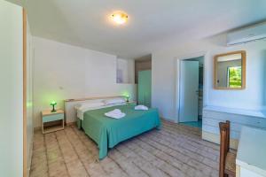 蓬扎Albergo Le Querce的一间卧室配有绿色的床和镜子