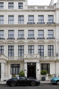 伦敦克利夫兰酒店的停在白色建筑前的黑色豪华轿车