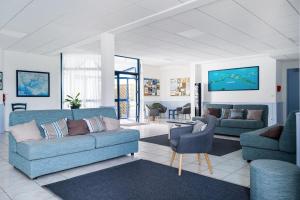 和尚岛Résidence Pierre & Vacances La Voile d'Or的客厅配有2张蓝色沙发和电视