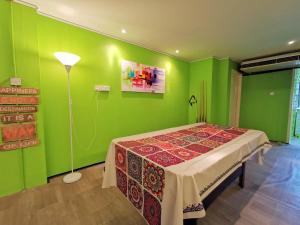 古晋AV HomeStay - Kuching MJC的绿色的客房配有桌子和灯具
