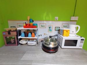 古晋AV HomeStay - Kuching MJC的厨房配有微波炉、炉灶和锅子