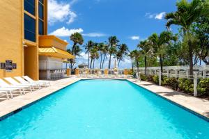 迪尔菲尔德海滩迪尔菲尔德海滩温德姆度假酒店的一座带椅子和棕榈树的度假村游泳池