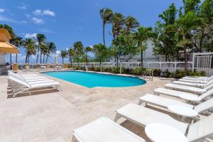 迪尔菲尔德海滩迪尔菲尔德海滩温德姆度假酒店的一个带白色躺椅的游泳池,一个度假村