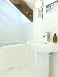 卡迪根The Attic Apartment, Quay Street Studios Cardigan的白色的浴室设有水槽和浴缸。