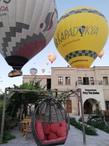 恰乌辛Cappadocia Fairy Tale Suites的一组热气球飞越一座建筑物