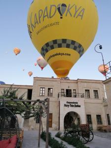 格雷梅Cappadocia Fairy Tale Suites的大楼前的黄色热气球