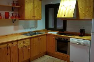 MontsonisCASA GRAN MONSONIS的厨房配有木制橱柜、水槽和炉灶。