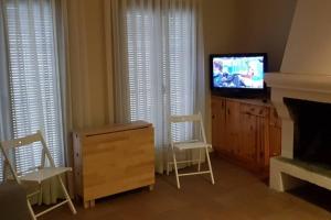 MontsonisCASA GRAN MONSONIS的客厅配有电视、2把椅子和梳妆台
