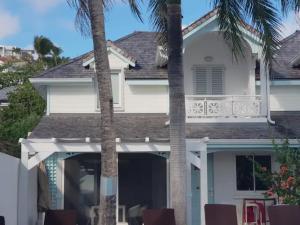 东方湾法国大街Villa White House, Orient Bay SXM avec piscine privée的一座棕榈树掩映的白色房子