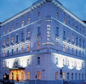 布拉格Hotel St George - Czech Leading Hotels的一座蓝色的大建筑,上面有标志