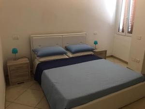 卡洛福泰Casa Francesca的一间卧室配有一张带蓝色床单和蓝色枕头的床。