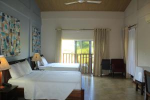 Bortianor博约海滩度假酒店的一间带两张床的卧室和一个阳台