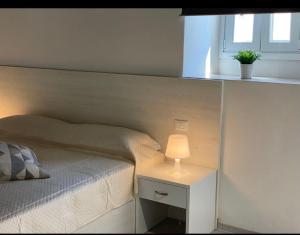 罗迪-加尔加尼科Villa Vittoria City的一间卧室配有一张床和一张带台灯的桌子