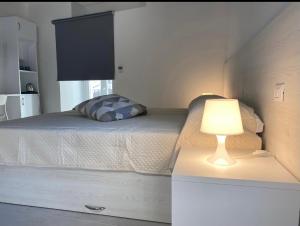 罗迪-加尔加尼科Villa Vittoria City的一间卧室配有一张床,在梳妆台上配有灯