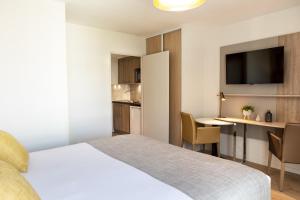 图卢兹Residhome Toulouse Ponts Jumeaux的酒店客房,配有一张床和一张桌子及椅子