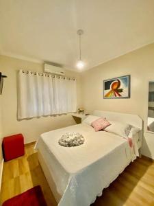 伊瓜苏科德斯道瓜旅馆的卧室配有白色的床和红色椅子