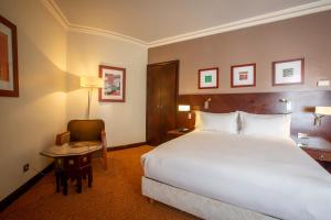 拉巴特大西洋阿格达勒住宿加早餐旅馆的酒店客房设有一张大床和一张桌子。
