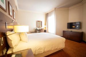 拉巴特大西洋阿格达勒住宿加早餐旅馆的卧室配有一张白色大床和电视。