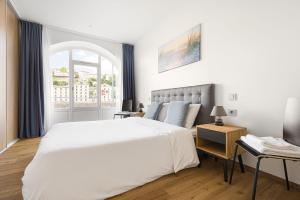 里昂Design et charme, 100m2 face à la Saône的卧室设有一张白色大床和一扇窗户。