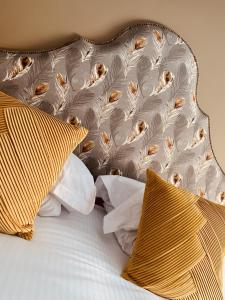 彭里斯酒廊酒店&酒吧 的一张黄色和白色枕头的床