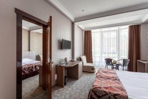 达戈米斯Планета Спорт的酒店客房设有一间带两张床和一张书桌的卧室