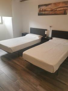 QuintanapallaHotel Rural Quintanapalla的铺有木地板的客房内的两张床