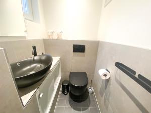 弗利辛恩Studio KA06 Het Strandhuis的一间带黑色水槽和卫生间的浴室