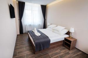 兹诺伊莫MP hotel的一间卧室配有一张带白色床单的床和一扇窗户。