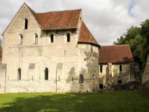 蒙特雷索Chateau-monastère de La Corroirie的一座带屋顶的古老石头建筑
